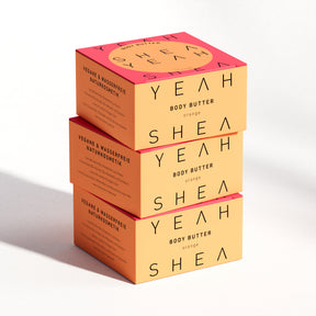 Shea Yeah Body Butter mit Orangenduft, drei Schachteln gestapelt, Naturkosmetik mit Sheabutter.