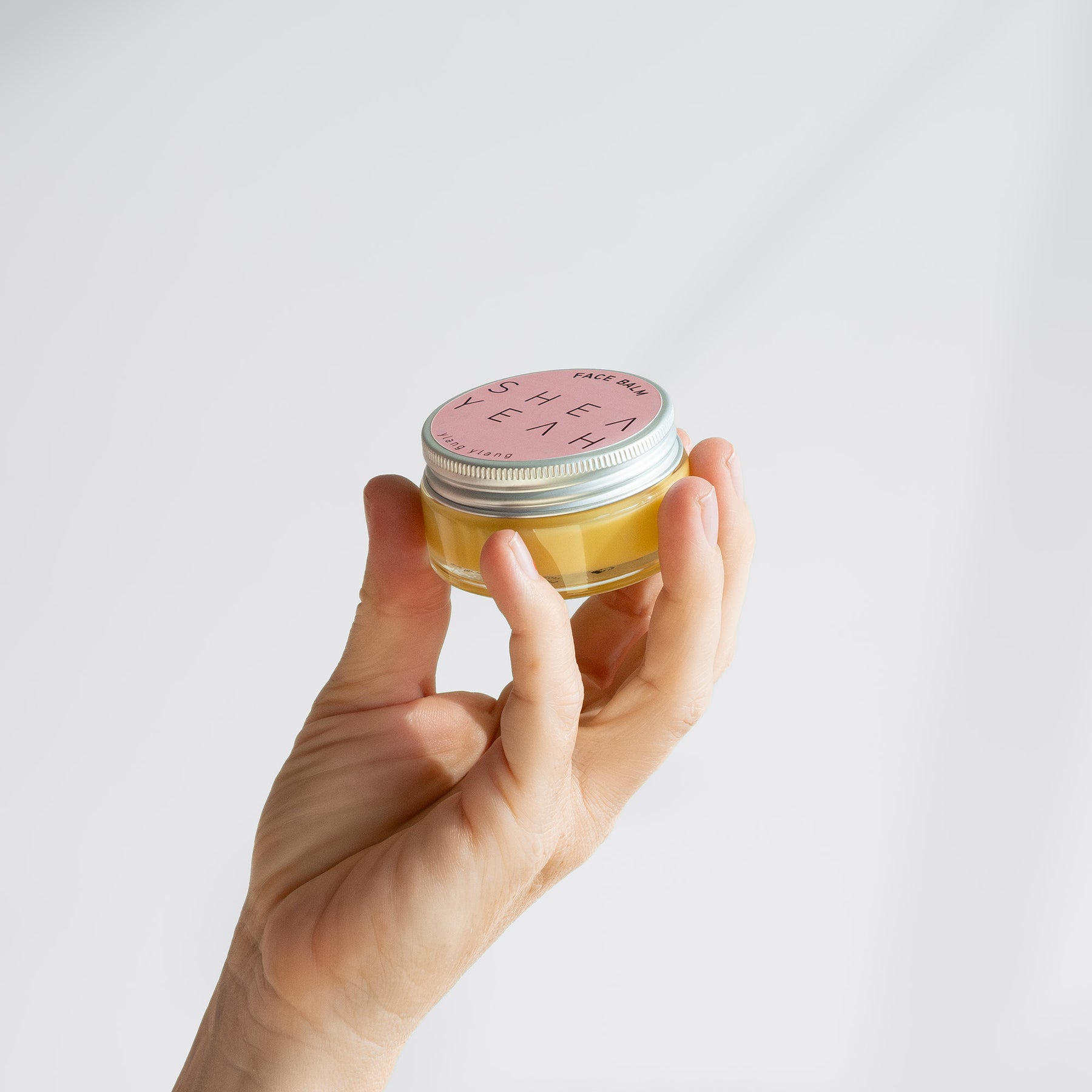Shea Yeah Face Balm mit Ylang-Ylang-Duft in der Hand gehalten.